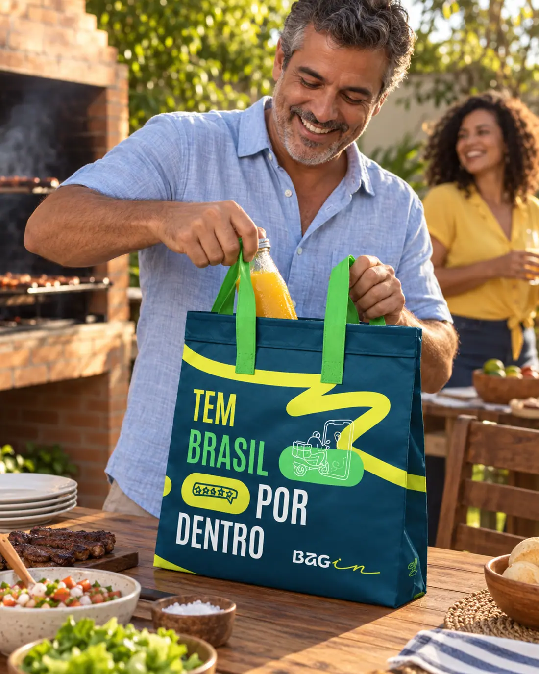 Homem retirando uma bebida da Bagin durante churrasco ao ar livre